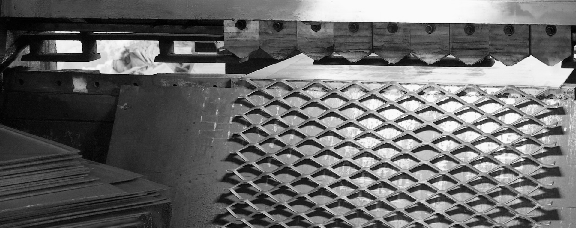 鋼板網機正在將鋼板進行沖壓擴張，制造鋼板網。